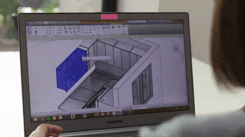 a woman working on 3d walkthrough animation services on her laptop with a building and buildings interior being created on the screen