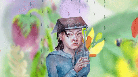 a girl holding a cup with a straw that leads to a book on her head that she is wearing like a hat and a dragon fly flies behind her and some big painted flowers in the background